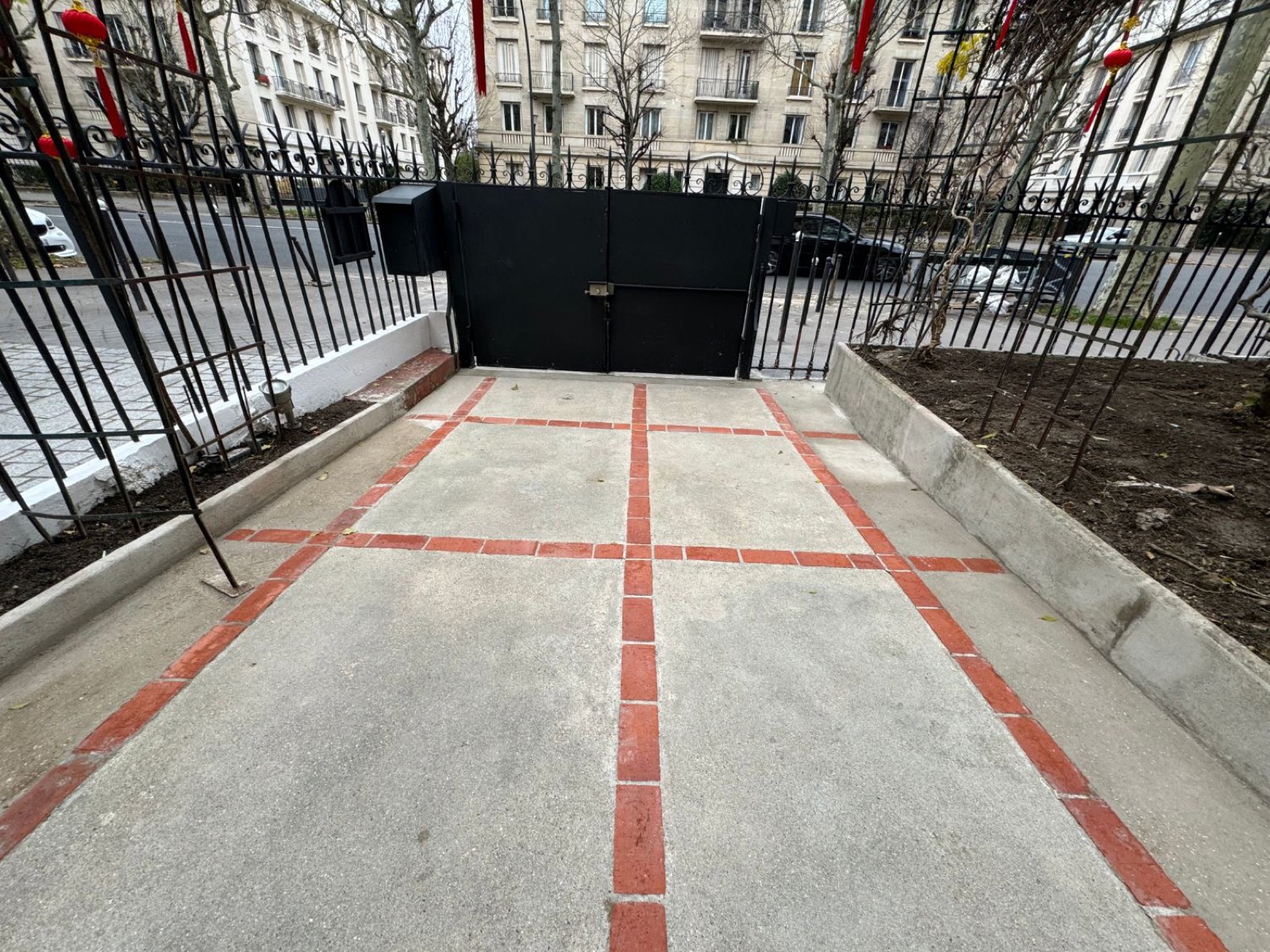 Vue d’ensemble de l’allée dallée devant le portail