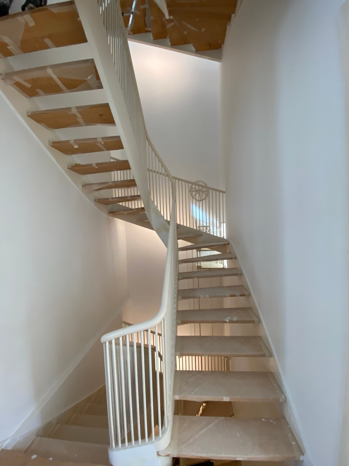 Cage d’escalier courbe avec balustrade repeinte