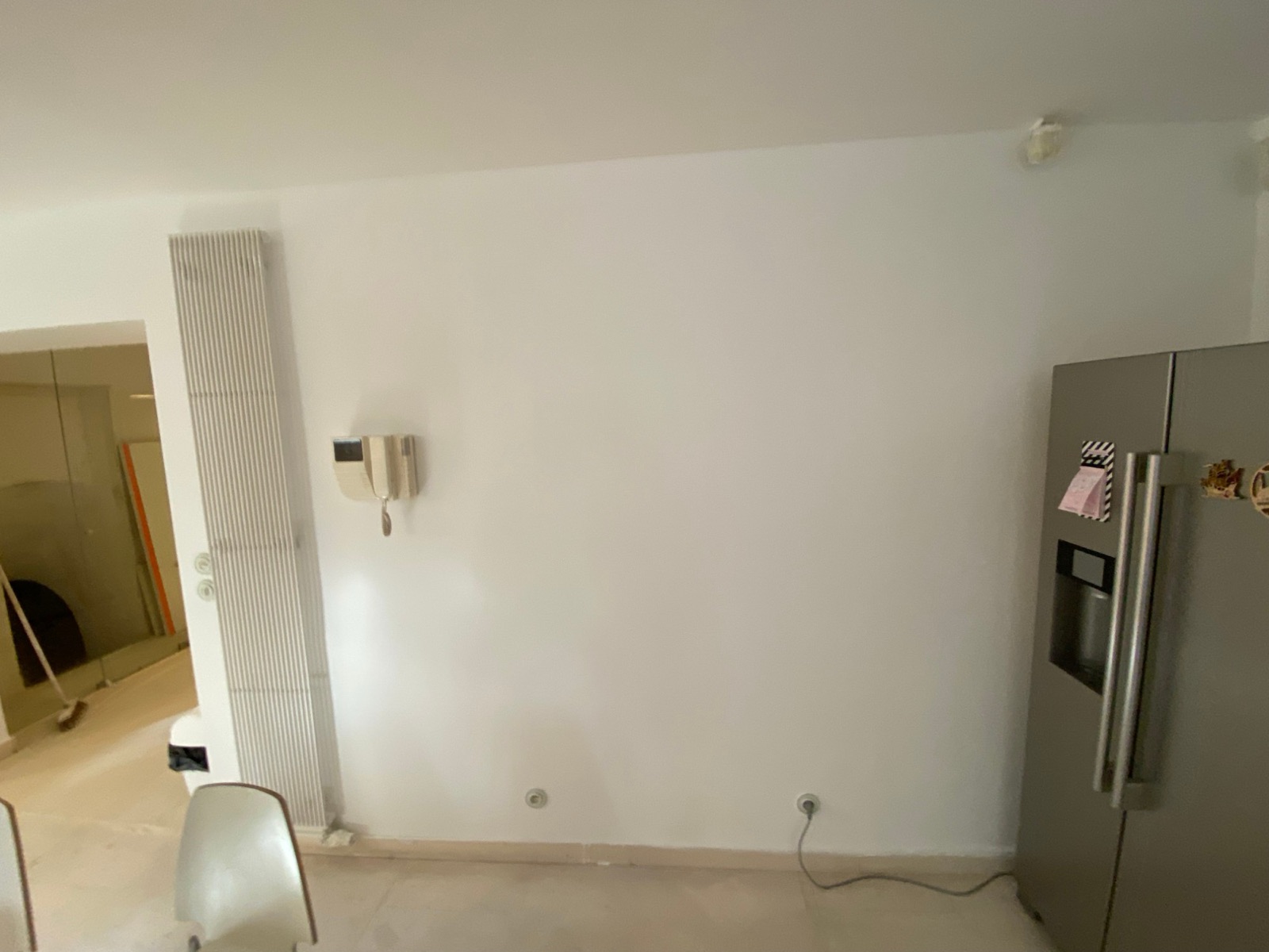 Mur repeint, interphone et radiateur