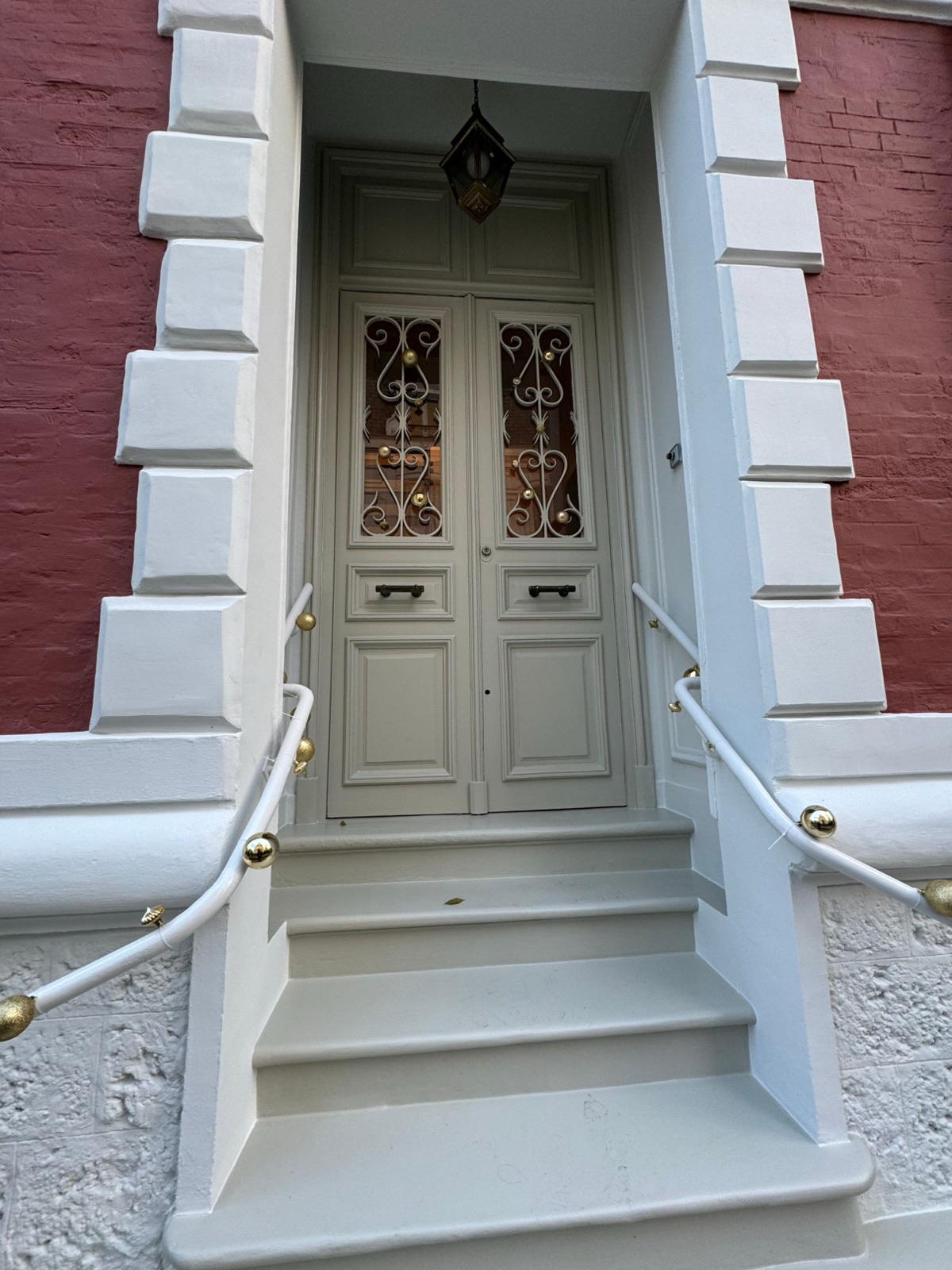 Porte d’entrée et perron encadrés par la façade rouge et blanc